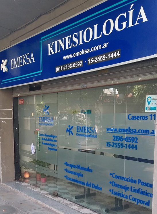 Vidriera del consultorio Emeksa con cartelería de Terapias Manuales, Fisioterapia y Drenaje Linfático